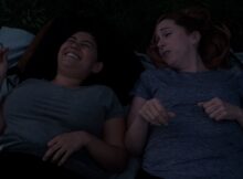 Two friends are laying on the ground while talking in a still from Sunspot