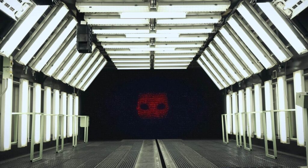 a huge screen showing a robotic face in film Project Dorothy