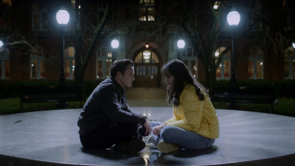 A man and a woman face each other while sitting on the floor in the film Step Back Doors Closing