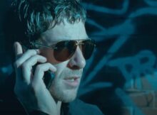 a man speaks on the phone in riot on redchurch street