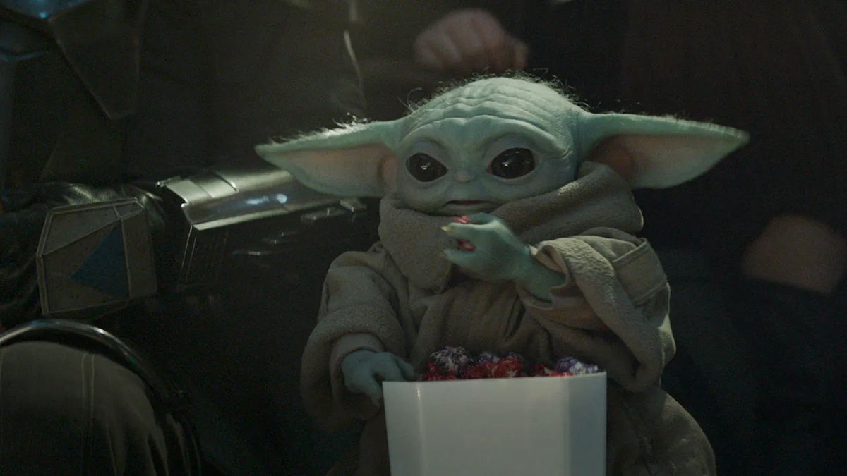 Grogu eating snacks while watching a gladiatorial fight.